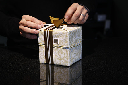 white and gray gift box on person's hand thumbnail