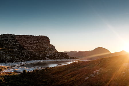 brown mountain near body of water at daytime thumbnail