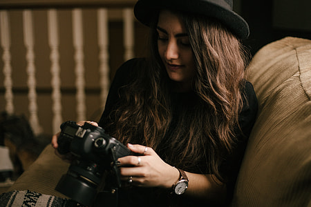 woman wearing black top holding DSLR camera thumbnail