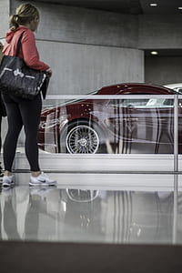 woman in black pants wearing black shoulder bag facing park car thumbnail