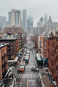 vehicles traveling on road near buildings thumbnail