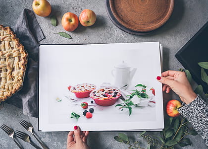 person holding photo of two pies on red bowl thumbnail