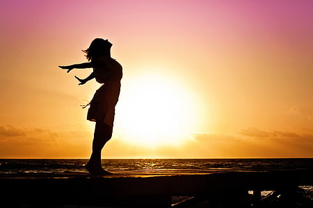 woman standing near sea during sunset thumbnail