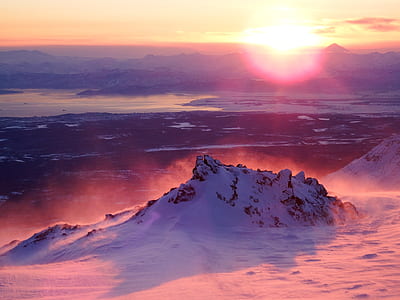 snow covered hill surrounded by snow during golden hour thumbnail