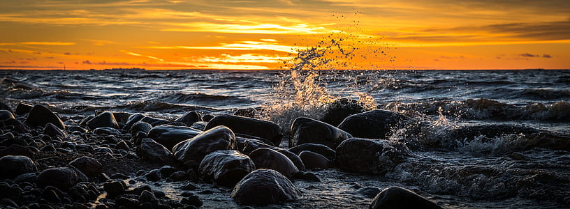waves splashing through rocks during golden hour thumbnail