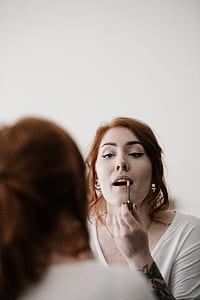 woman putting lipstick thumbnail