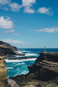 man standing on black rock formation thumbnail