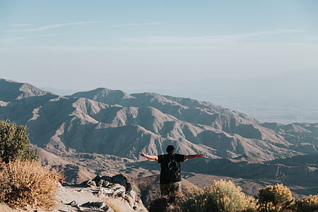 man raising arms at mountain thumbnail