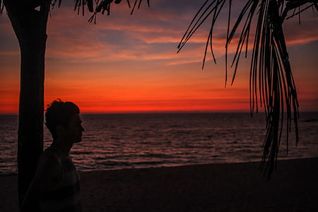 man leaning on the post near the shore thumbnail