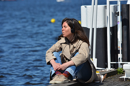 woman sitting on grey surface near ocean thumbnail