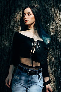 woman wearing crop top leaning on tree trunk thumbnail