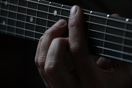person hands on guitar fret thumbnail