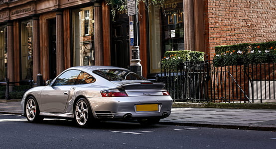 silver coupe in front of the brown building thumbnail