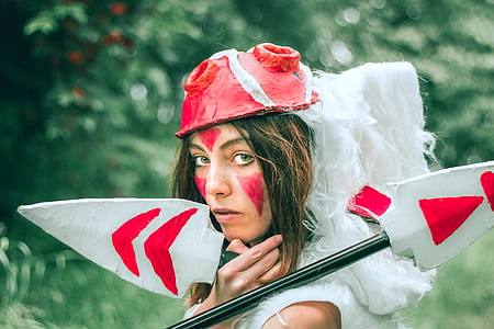 woman wearing red helmet holding tow white and red spears thumbnail