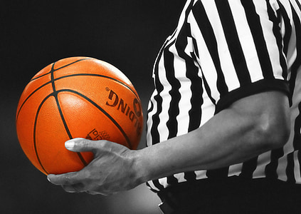 man with white and black striped shirt holding orange Spalding basketball thumbnail