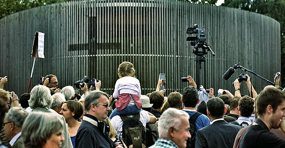 people gathered around building with cross thumbnail
