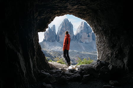 silhouette photography of man at cave hole thumbnail