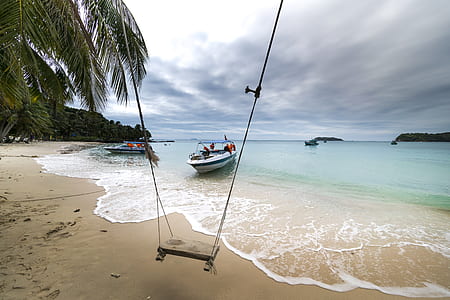 swing near body of water under cloudy sky thumbnail