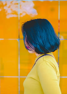 woman standing beside yellow wall tiles thumbnail