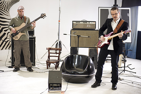 two men each playing electric guitar and electric bass guitar thumbnail