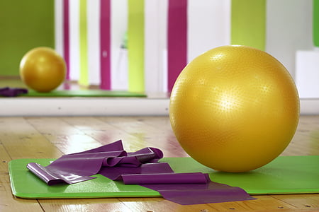 round yellow gym ball and green yoga mat thumbnail