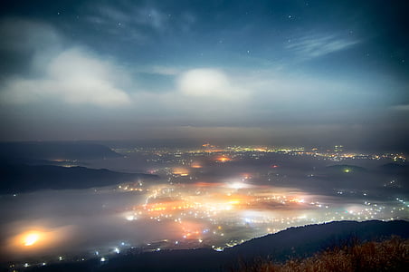 aerial photography of city light near fogs and mountain thumbnail