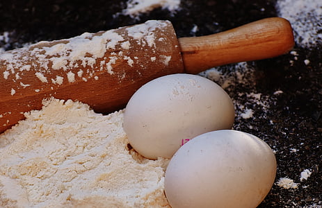 two white eggs beside rolling pin thumbnail