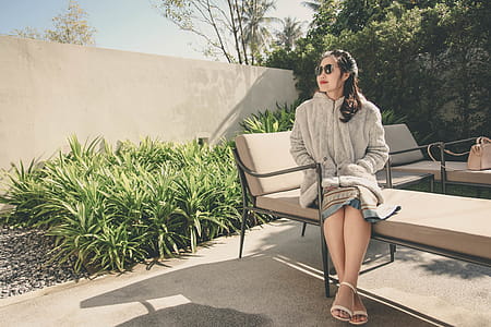 Woman Wearing Hoodie Sitting on Lounge Chair thumbnail