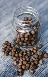 brown seeds inside clear glass jar on gray plank thumbnail