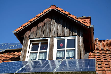 low angle photo of solar panels and house under blue sky thumbnail