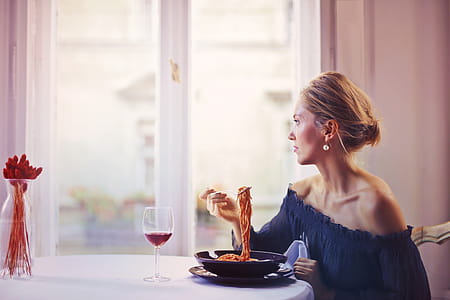 Woman Sitting on Chair While Eating Pasta Dish thumbnail