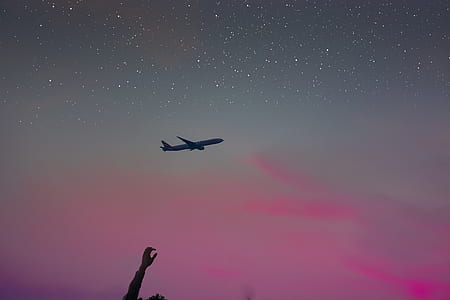 airplane over silhouette of person under starry sky thumbnail