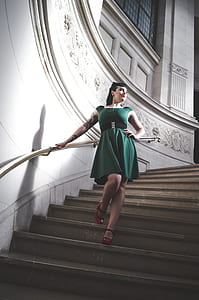 woman wearing green scoop-neck sleeveless mini dress while holding rail and walking on stairs thumbnail