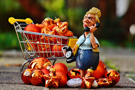 woman holding telephone figurine stand beside ball ornaments thumbnail