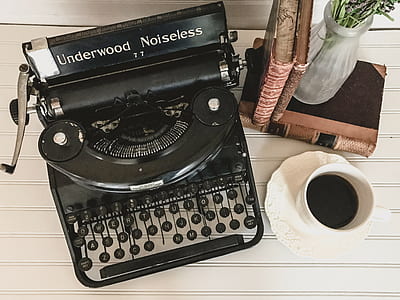black Underwood Noiseless typewriter near white ceramic coffee mug thumbnail