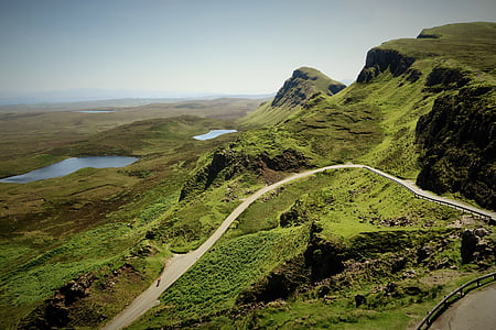 aerial view of mountain and road under white sky thumbnail