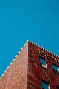 brown concrete high rise building under blue sky thumbnail