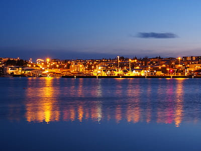 lighted buildings and houses near ocean during sunset thumbnail