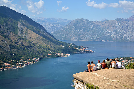 group of people sitting on cliff during daytime thumbnail