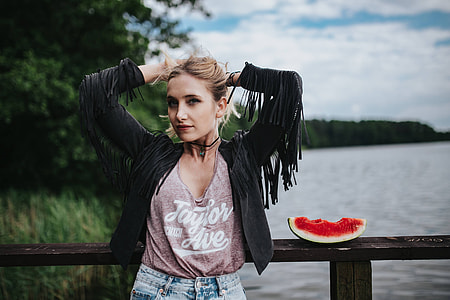 Blonde woman having a healthy snack at the wooden pier thumbnail