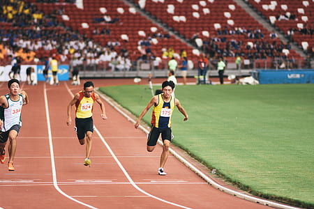 man in yellow tank top and black shorts running on track field thumbnail