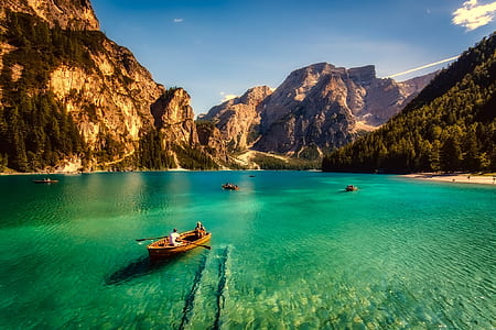 person riding boat towards rock formation thumbnail