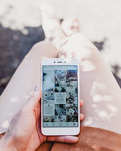 person holding smartphone displaying instagram post thumbnail