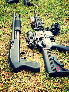 black modern rifle and black shotgun on grasses thumbnail