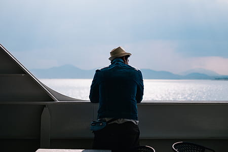 man wearing blue jacket and bat leaning on rails thumbnail