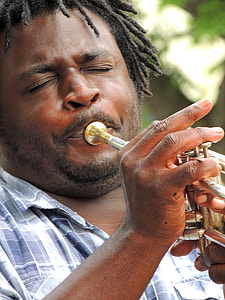 man in blue shirt playing a brass instrument thumbnail