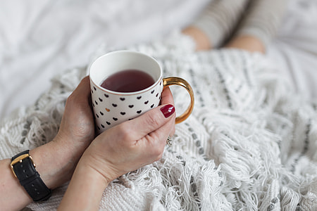 Soft photo of woman on the bed with the book and cup of coffee in hands thumbnail