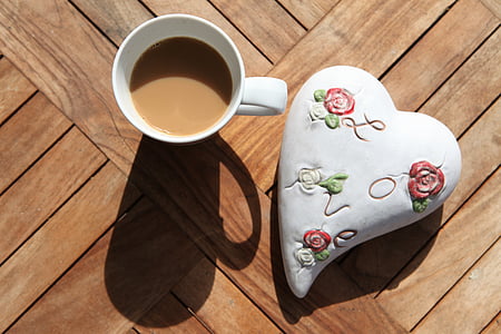 white coffee cup beside white and red heart ornament thumbnail