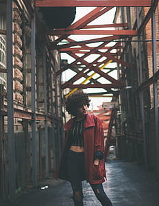 woman wearing red coat posing on pathway thumbnail
