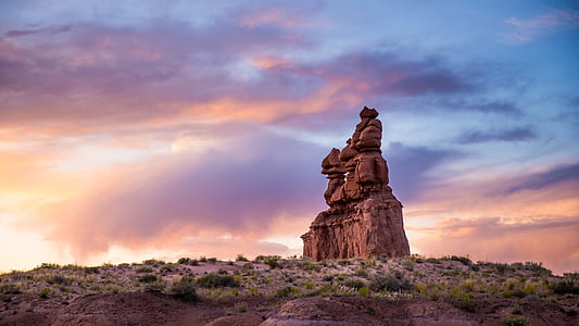 brown rocks piled on cliff under clodu sky thumbnail